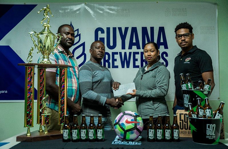 Co-Organiser Virgil Watts receives the sponsor’s cheque from Guyana Breweries Inc.’s Marketing Manager, Melinda Telesford. Also in photo is Seweon McGarrell, Head of Trade Marketing (first from right) and Co-Organiser Lynton Luke, head of Cool Crew Promotion.