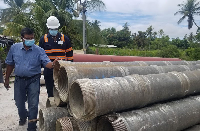 GWI's CEO, Shaik Baksh inspects material at the well drilling site
