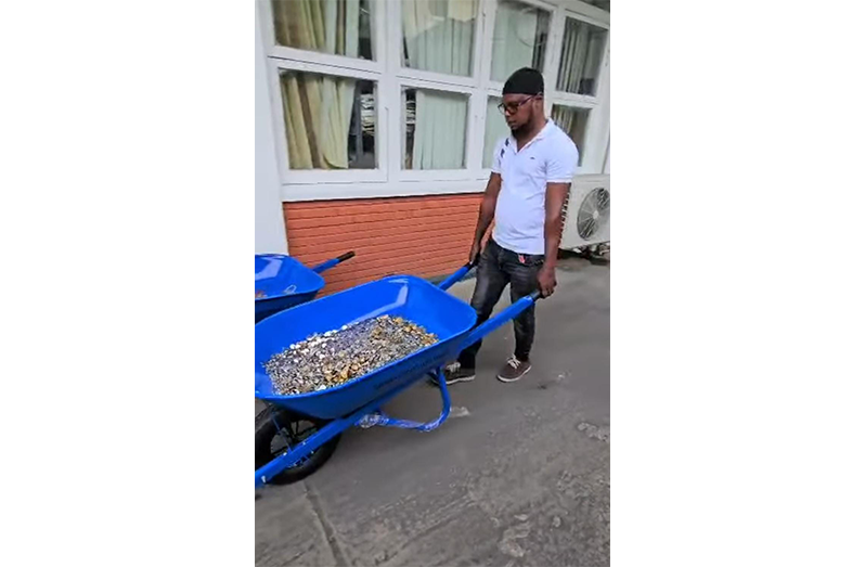 One of Mohamed's associates removing the wheelbarrow of coins