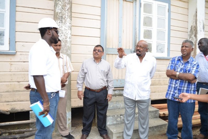 Minister Norman Whittaker, Region Five Chairman Bindrabhan Bisnauth and Regional Executive Officer (REO) Ashford Ambedkar engaging Quacey Amsterdam, the contractor at the Novar Primary School, Region 5 on Friday last.