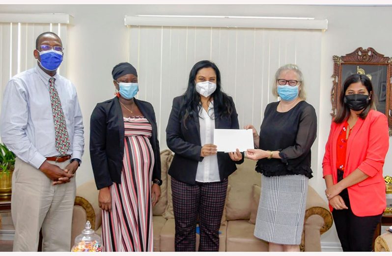 Human Services Minister, Dr. Vindhya Persaud (centre) accepts two scholarships for the Ministry from Nations Director, Pamela O'Toole, as Permanent Secretary, Shannielle Hoosein-Outar (right), Nations Chief Executive Office, Dr Dexter Phillips, and another staff of the school look on