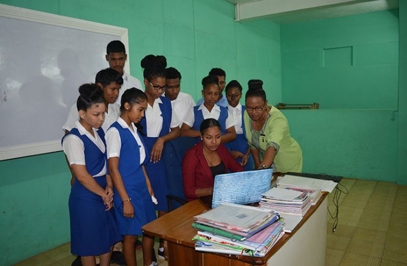 Ms. Carmel Williams, Head Teacher of Bartica Secondary School (right) inspecting a teaching session being conducted by her daughter, Ms Leah Smith (seated), in the Information Technology (IT) laboratory