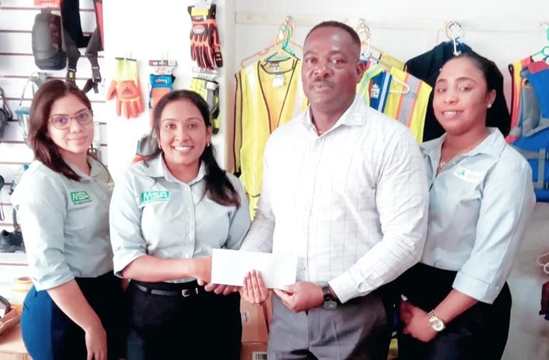 – Industrial Safety Supplies Inc. Office Manager, Ms. Crystal Kallu hands over sponsorship to WSUCC president, Franklin Wilson, in the presence of her colleagues, Ms. Nyeesha Joseph and Mechaela Hohenkirk.