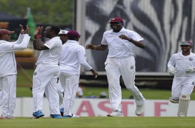 West Indies celebrate the opening breakthrough when Kemar Roach, seen here receiving a high-five from Shiv Chanderpaul, removed Alviro Petersen. (AFP)