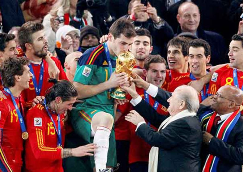FIFA president Sepp Blatter (2nd R) and South African President Jacob Zuma (R) hand the World Cup trophy to Spain's team captain Iker Casillas (C) during the award ceremony at Soccer City stadium in Johannesburg July 11, 2010. 
(REUTERS/Michael Kooren)