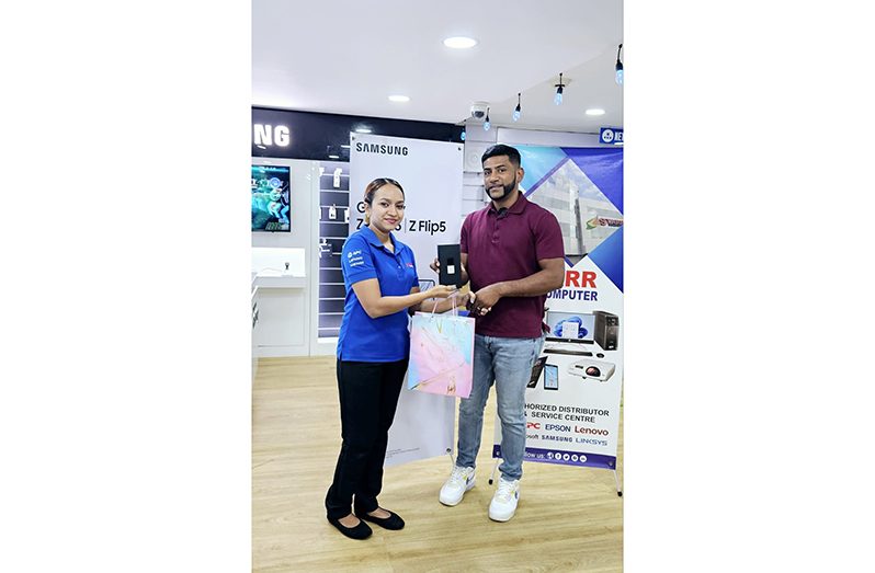 (From left) STARR Computer Sales Supervisor, Roschel Samaroo and winner Mohamed Rahaman