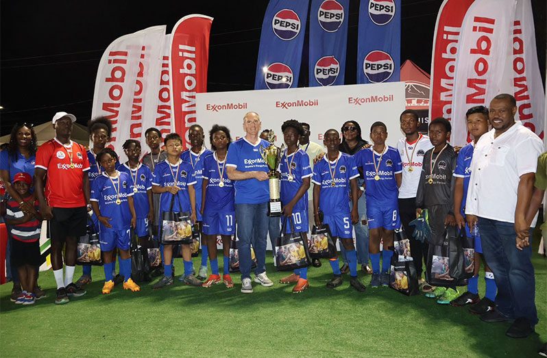 Chase boys collect their prize from Alistair Routledge - President & General Manager of ExxonMobil Guyana for winning the U14 title