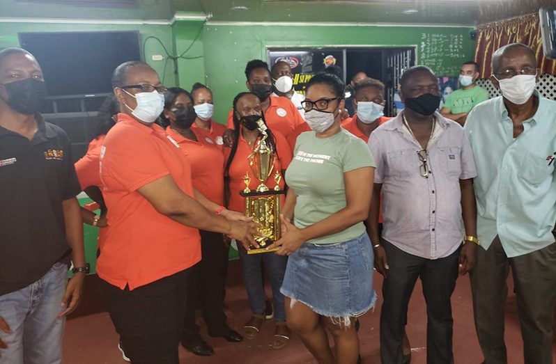 Lovern Spencer hands over the winners’ trophy to captain Claire Benjamin of Cody Girls. Also in picture is team manager Neville Cadogan.