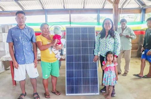 Minister of Amerindian Affairs Pauline Sukhai distributing solar panels to a hinterland family earlier this year