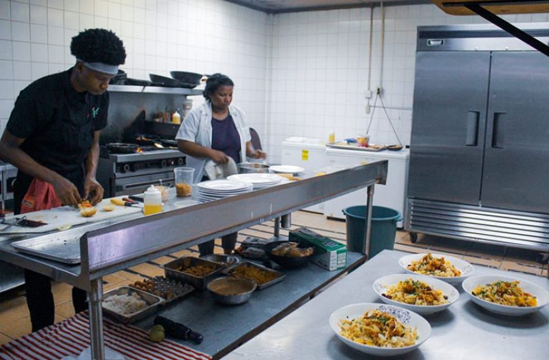 Chef Alicia Browne and her younger helper cooking in the kitchen at Xie Xie