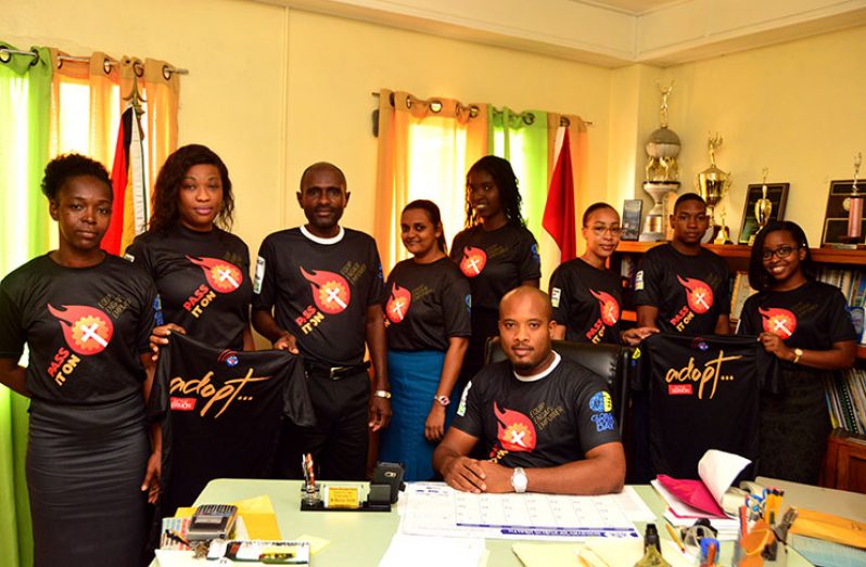 Youth Director, Pastor Marvyn Smith (seated) and Assistant Youth Director Lennox Jason (third left) display the t-shirts which will be worn by the youths on Global Youth Day on March 16, 2019 (Adrian Narine photo)
