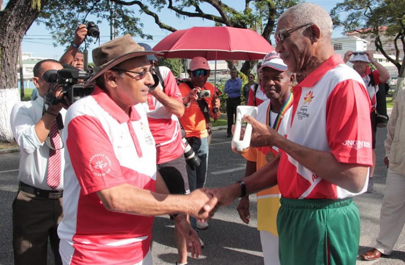 President David Granger receiving the Baton from President of the Guyana Olympic Association (GOA), K.A. Juman Yassin