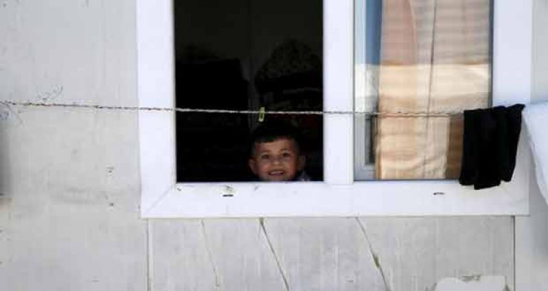 (Yazidi boy Emad, 5, looks out of his family’s home at a refugee camp near the northern Iraqi city of Duhok April 19, 2016. (REUTERS/Ahmed Jadallah)