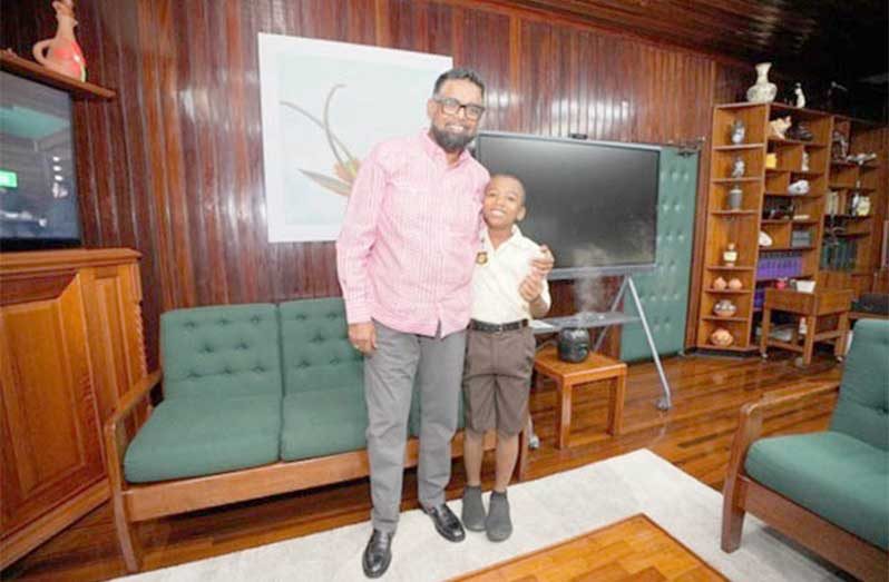 President Dr Mohamed Irfaan Ali and ten-year-old Treyson Mahadeo share a photo-moment on Tuesday