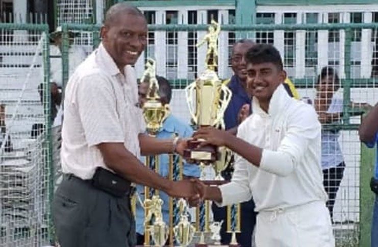 GCC’s U-17 captain, Zachary Jodah, collects the Friends of Cricket 100-over championship trophy from president of the GCA, Roger Harper.