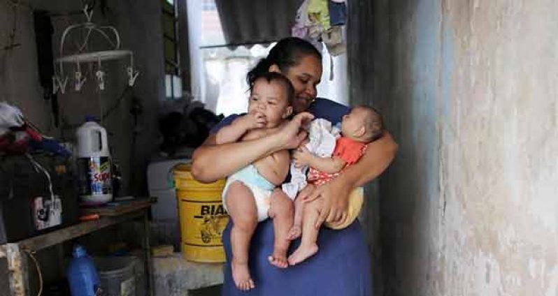 Jaqueline (L), 25, holds her five-month-old twins, Laura (R) and Lucas at their house in Santos, Sao Paulo state, Brazil April 20, 2016. REUTERS/Nacho Doce