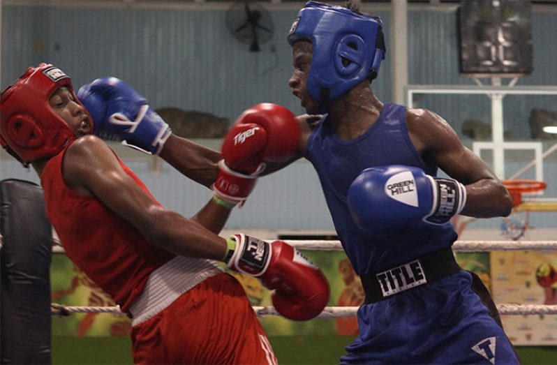 Isaiah Moore (right) was aggressive in his bout against Abdul Taylor from T&T