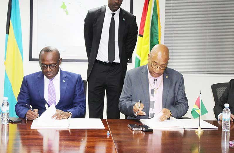 Isaac Chester Cooper, The Bahamas’ Deputy Prime Minister and Minister of Tourism, Investments and Aviation and Bishop Juan Edghill, Minister of Public Works, sign the ‘open-skies’ agreement (MoPW photo)