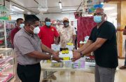 Agriculture Minister, Zulfikar Mustapha, receiving veterinary supplies from a representative of Poonai's Pharmacy and General Store