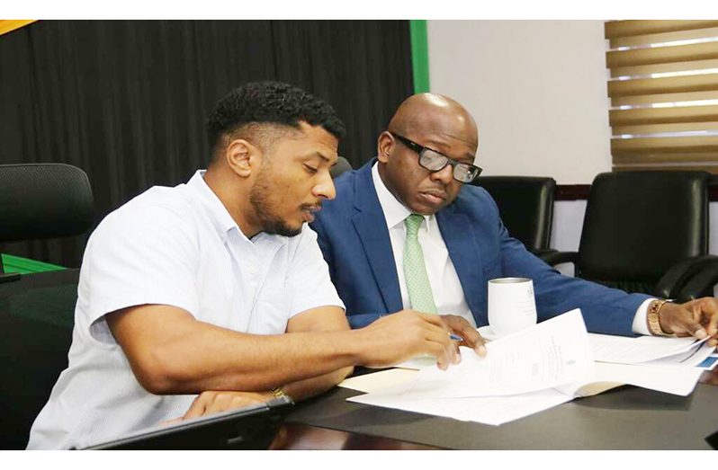 Minister of Agriculture and Fisheries, Pearnel Charles Jr (right), and Acting Principal Director of Agricultural Economic Planning & Policy, Kevin Condappa, peruse a document, during a virtual meeting with Cuba’s Deputy Minister of Agriculture, Maury Hechavarria Bermudez, on December 20 (Jamaica Observer photo)