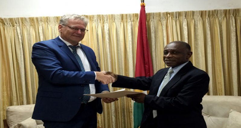 Ambassador Jernej Videti [left] presenting copies of his credentials to Minister Carl Greenidge.