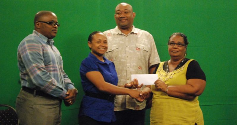 Acting Sports Editor of National Communications Network Alethea Grant-Charles (2nd left) hands over the sponsorship cheque to secretary of the Berbice Cricket Board Angela Haniff, even as CEO (ag) of NCN Michael Gordon (left) and Hilbert Foster look on appreciatively. (Photo by Cullen Bess-Nelson)