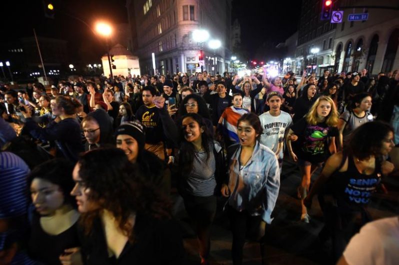 Protesters against president-elect Donald Trump march peacefully through Oakland, California, U.S., November 9, 2016.  A separate group earlier in the night set fire to garbage bins and smashed multiple windows. REUTERS/Noah Berger