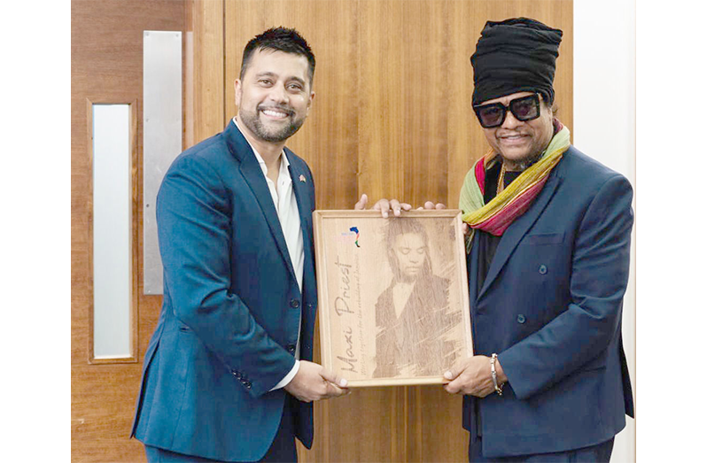 Maxi Priest and Faizal Khan with a signed Maxi Priest greenheart wooden engraved plaque created by Branderz Guyana