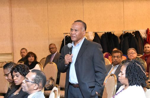 A member of the audience poses a question to Minister Trotman during the question and answer session