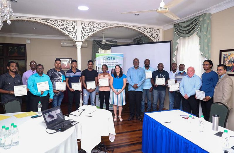 Prime Minister, Brigadier (Ret’d), Mark Phillips (centre) flanked by trained and certified mechanics and auto-technicians in electric vehicle maintenance and repairs