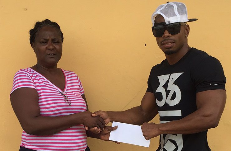 Mr. Physique’ Emmerson Campbell (left) accepts the sponsorship cheque from GCS committee member, Avril Black.