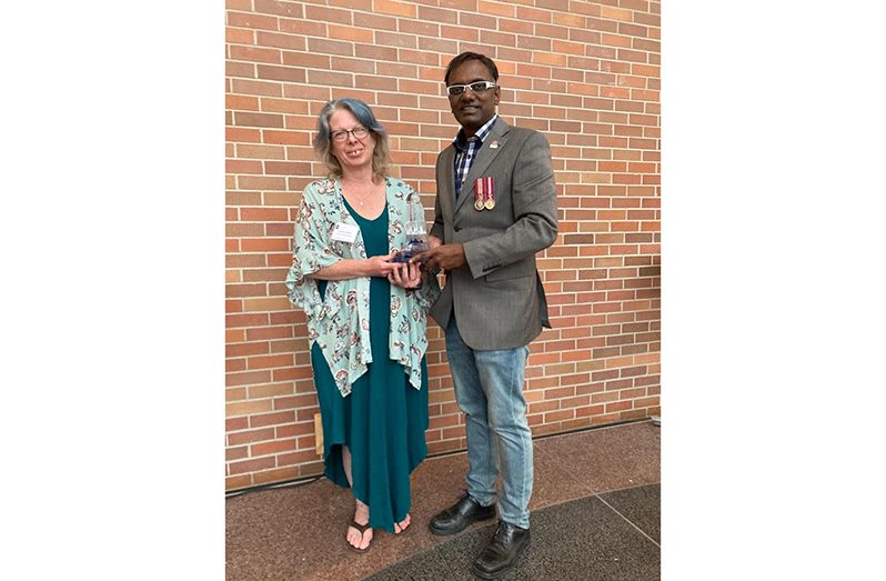 Narine Dat Sookram receives the Lighthouse award from Board member Colene Allen