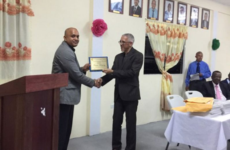 Businessman Poonai Bhigroog receives his award from Business Minister Dominic Gaskin