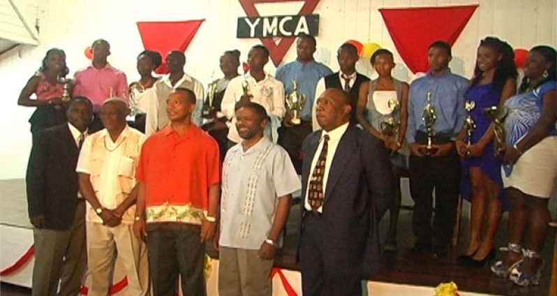 The awardees and officials pose for a group photo following the presentation.
Alika Morgan and Winston George are third and fourth from left (Backrow).