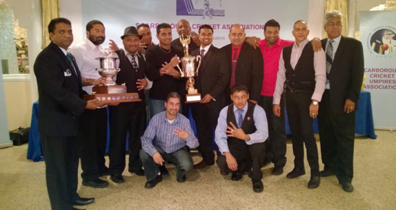 MEMBERS of Hawaiian Arctic Cricket Club pose with their winnings. At extreme right is SCA president, Deo Samaroo. Chief Financial Officer, Vish Jadunauth, is extreme left, while HACC owner, Archie Mohan, is fourth from right (standing). (Picture courtesy of Azad Khan