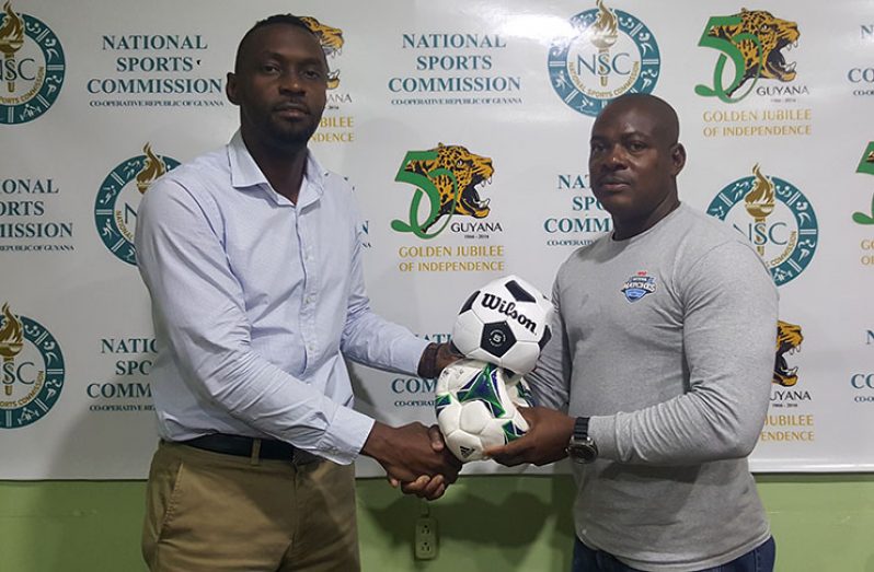 Director of Sport Christopher Jones (left) hands over footballs to EBFA president Franklin Wilson.