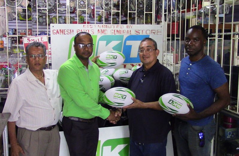 From left, CEO of Ganesh Parts and General Store, Chatram (Roop) Persaud, watches as Sales Manager Suresh Rampersaud hands over BKT-sponsored rugby balls to president of GRFU, Peter Green and PRO Esan Griffith.