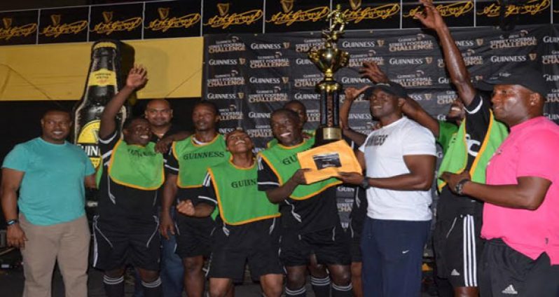 Flashback! Lee Baptiste (right), Banks DIH Guinness Brand Manager, hands over the winners’ purse of $500 000 and the championship trophy to captain of the victorious North Ruimveldt unit Joshua Browne, following his team’s dominance in the sixth annual Georgetown Guinness ‘Greatest of De Streets’ tournament.