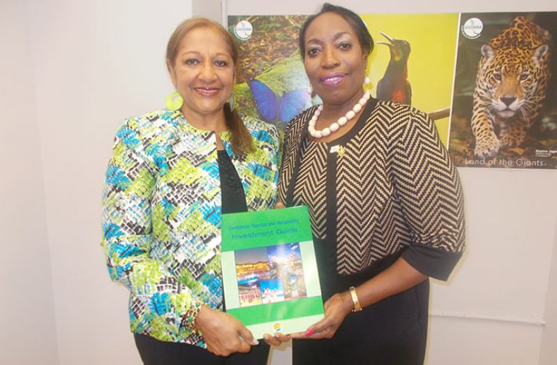 Editor of the Caribbean Investment Guide, Sandra Ann Baptiste, hands over a copy of the publication to Guyana’s Consul-General in New York, Barbara Atherly.