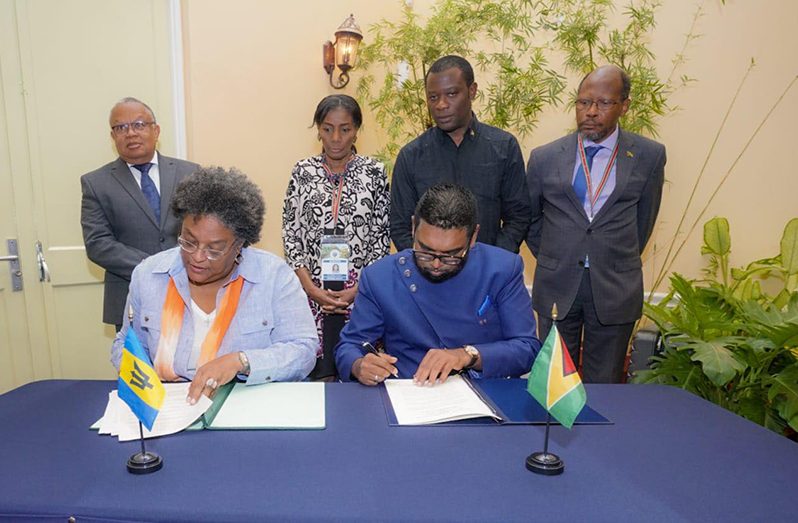 President, Dr. Irfaan Ali (right) and Barbados Prime Minister Mia Mottley signing the updated agreement