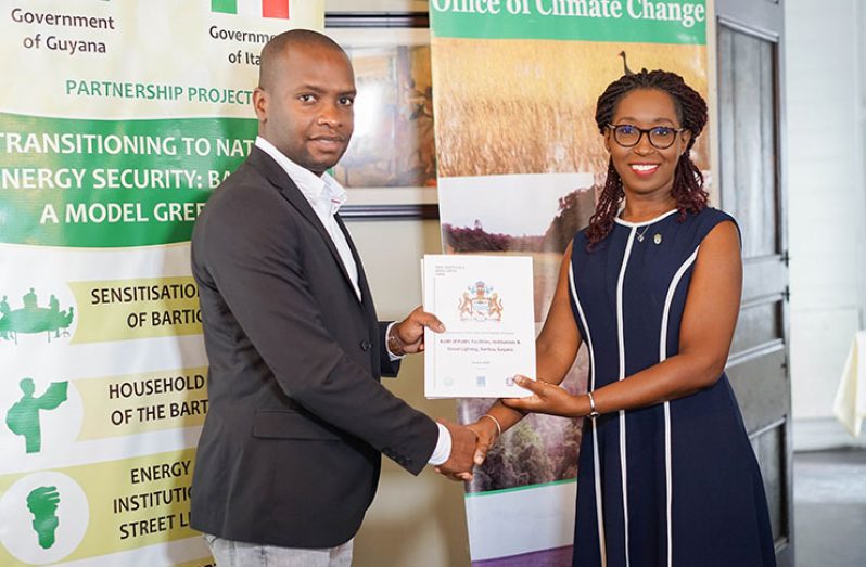 Head of the Office of Climate Change, Mrs. Janelle Christian, handing over the completed studies and audits from phase one of the Italian Government-funded project to Mayor of Bartica, Mr. Gifford Marshall