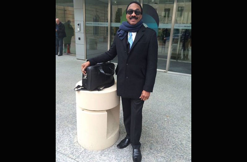 Attorney General Basil Williams stands in front of the OECD Conference Centre in Paris, France