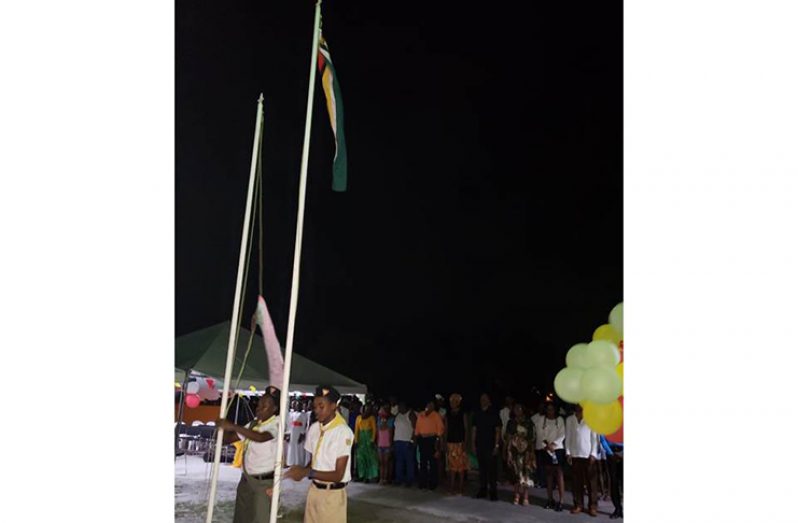 Two members of the Youth Movement of the Victoria SDA Church hoisting the flags