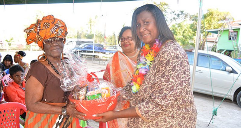 Public Relations Officer (PRO) for the Ministry of Culture, Youth and Sport, Yvonne Cole handing over the gift basket to Gonzales