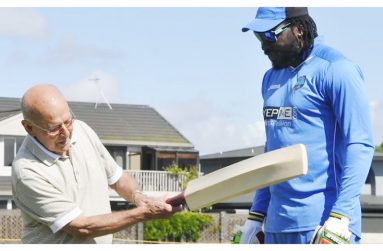 Bruce Pairaudeau tests his drive with Chris Gayle's bat in 2015 (WICB)