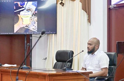 MARAD’s Marine Superintendent Christopher Bailey testifies before the Presidential Commission of Inquiry (CoI) into the July 18 MV Barima tragedy. Also pictured (left) is the Emergency Position-Indicating Radio Beacon (EPIRB) he recovered while participating in the search and rescue operation