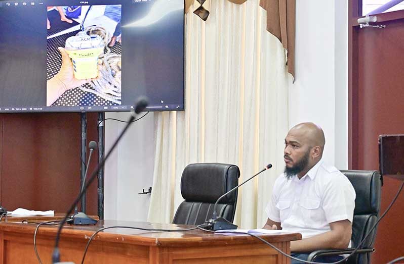 MARAD’s Marine Superintendent Christopher Bailey testifies before the Presidential Commission of Inquiry (CoI) into the July 18 MV Barima tragedy. Also pictured (left) is the Emergency Position-Indicating Radio Beacon (EPIRB) he recovered while participating in the search and rescue operation