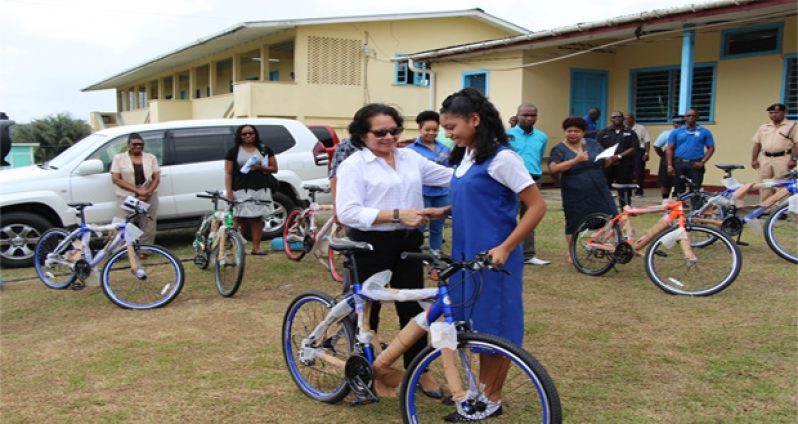 First Lady Mrs. Sandra Granger shakes the hand of this shy Bartica Secondary School student who is about to receive her brand new bicycle