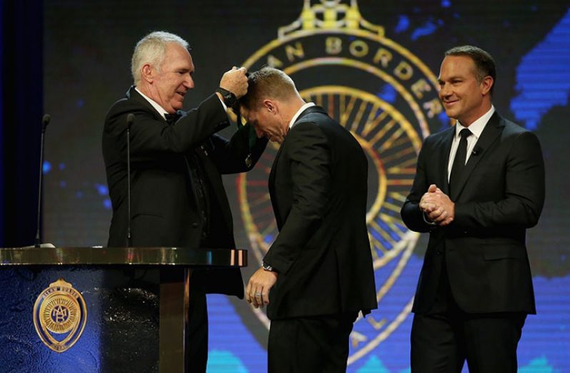 David Warner receives the biggest prize from former Australian captain Allan Border in Sydney yesterday.