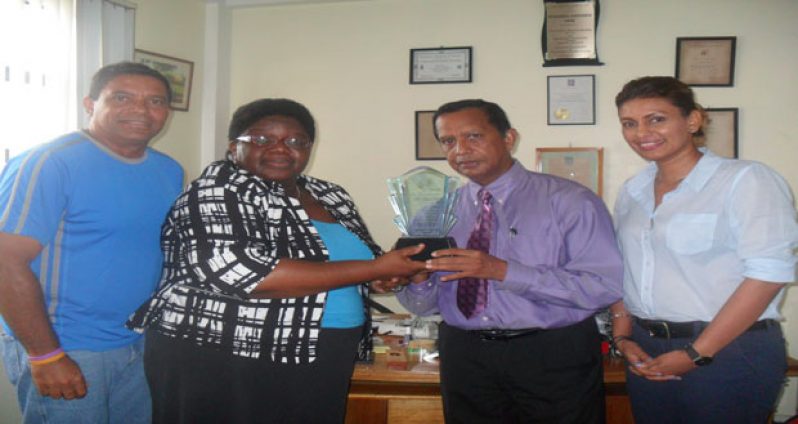 In photo Ms McCalman presents a plaque to Mr Panday Looking on approvingly are Mr John Goede, ITF Development Officer for the Caribbean and Ms Elizabeth Persaud, treasurer of the Guyana Lawn Tennis Association.